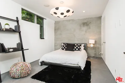 a bedroom with a bed and a painting on the wall