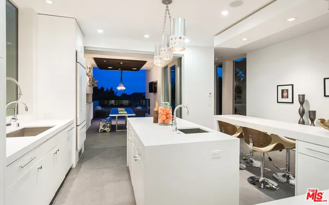 a kitchen that has a sink and a stove with white walls