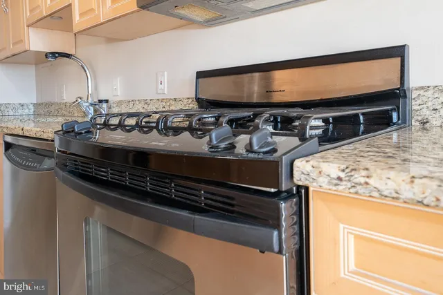 a close view of kitchen sink stove and oven with wooden floor