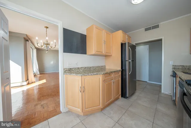 a kitchen with granite countertop a refrigerator and a stove top oven