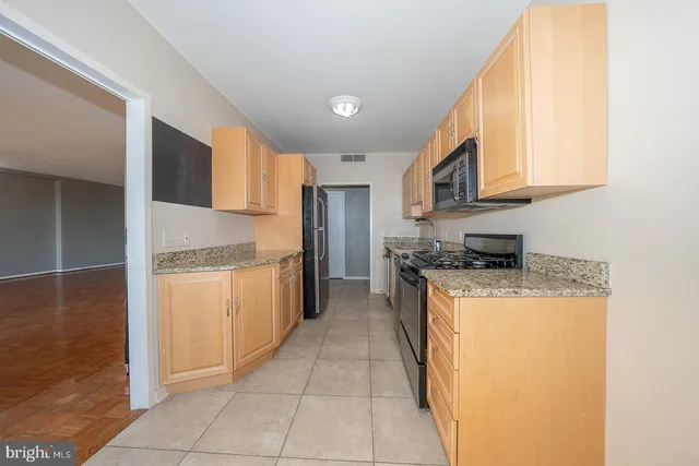 a kitchen with stainless steel appliances granite countertop a stove a sink and a refrigerator