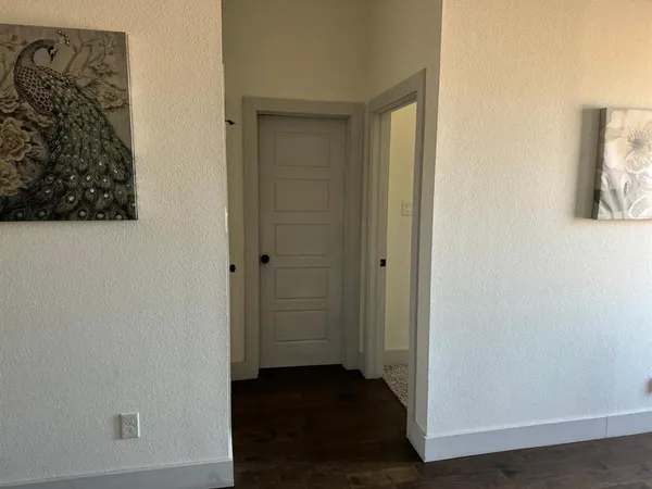 a view of a hallway with wooden floor and closet