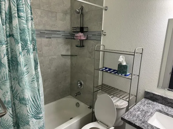a white toilet sitting next to a bath tub and shower
