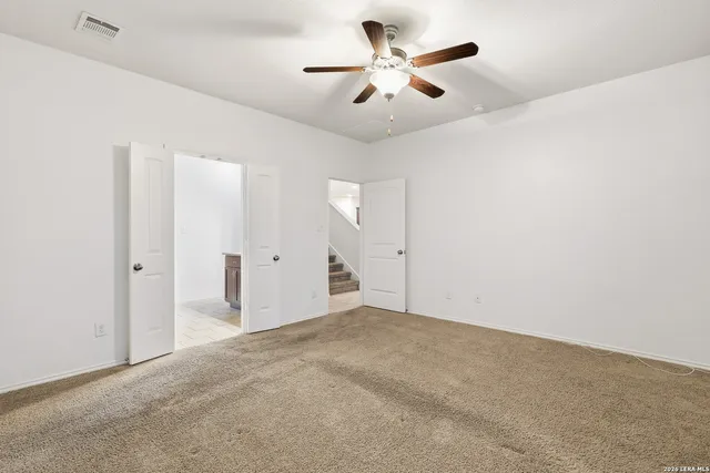 an empty room with fan and a ceiling fan