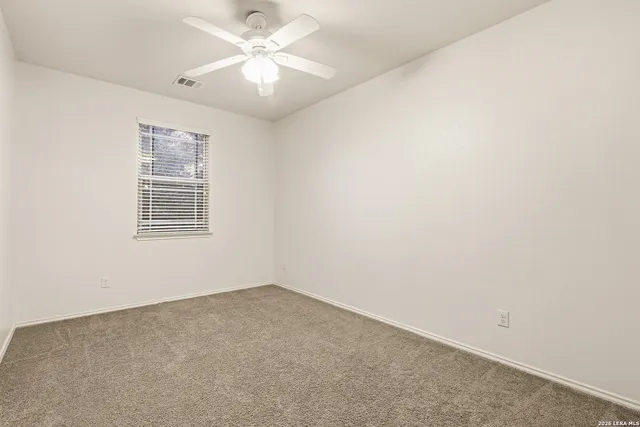 an empty room with a window and a fan