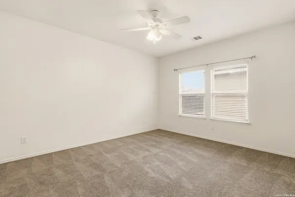 an empty room with a window and a fan