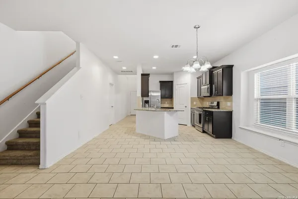 a large kitchen with stainless steel appliances kitchen island granite countertop a sink and a stove