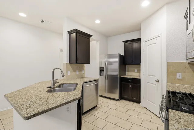 a kitchen with stainless steel appliances granite countertop a sink stove and refrigerator