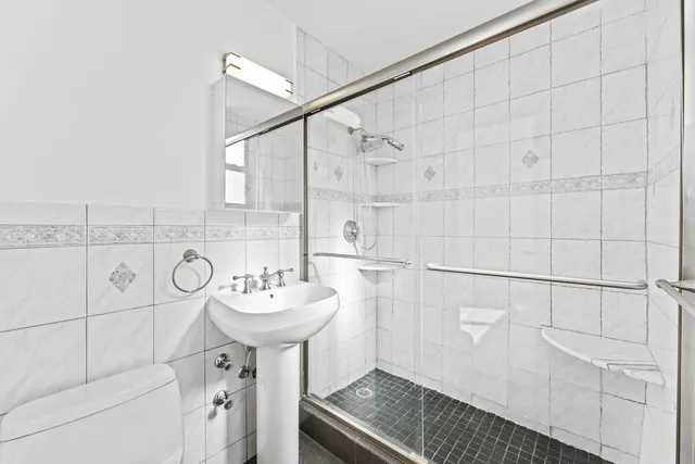 a bathroom with a sink a toilet and shower