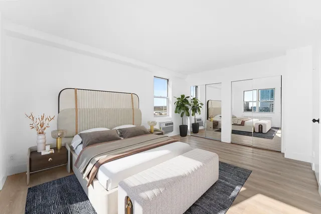 a bedroom with a bed a couch and potted plant