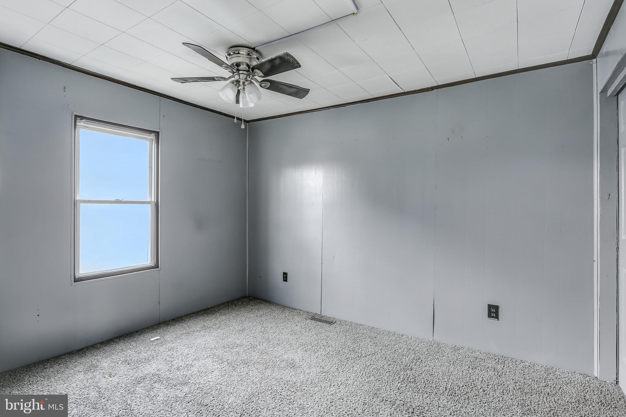 212 Beaver Road, Unit 1 Harrisburg, PA 17112 - Photo 5 of 11 an empty room with a ceiling fan and windows