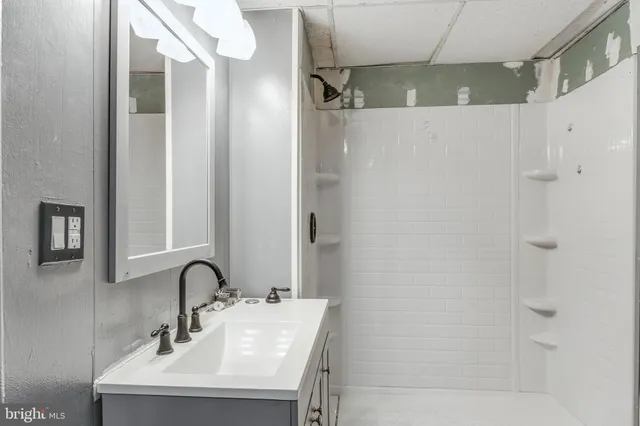 an empty room with windows and ceiling fan