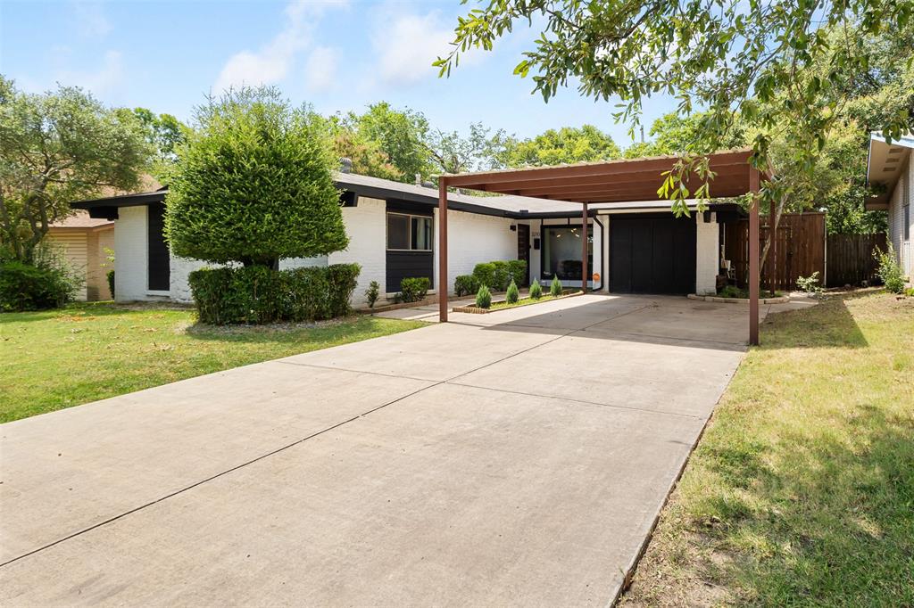a view of a house with a yard and potted plants