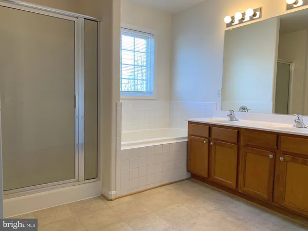a bathroom with a tub sink and mirror