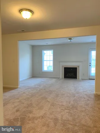 a view of empty room with window and fireplace