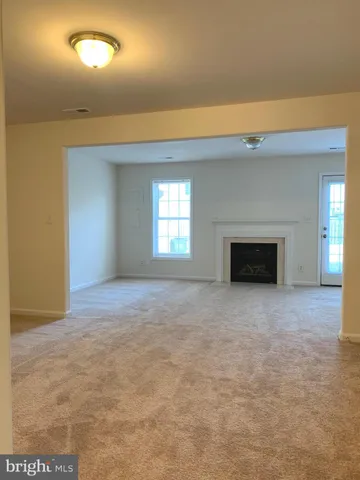 a view of empty room with window and fireplace