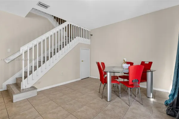 a view of a dining room with furniture a rug and wooden floor