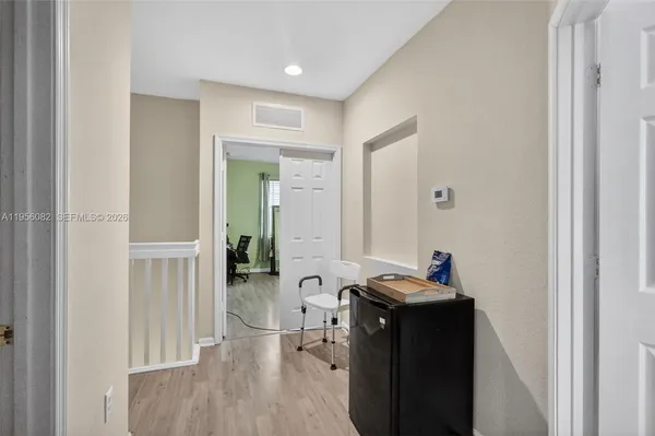 a view of a hallway with furniture and wooden floor