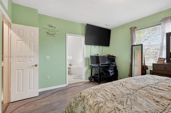 a bedroom with a bed and a flat screen tv