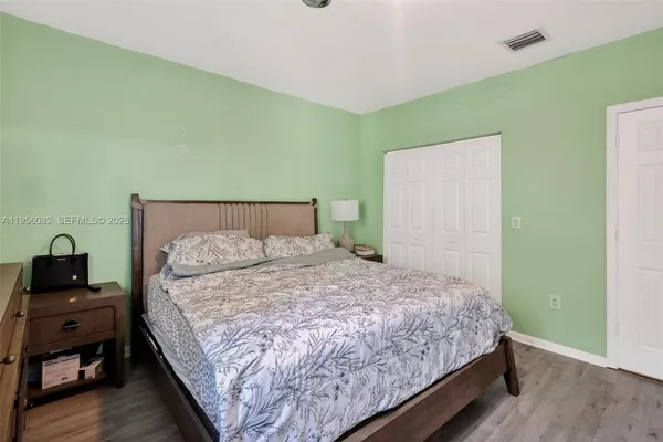 a bedroom with a bed and wooden floor