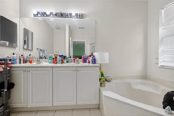 a bathroom with a tub sink and mirror