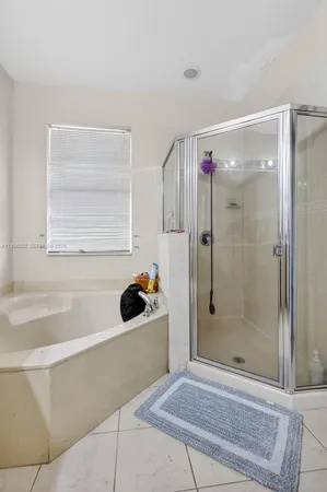 a bathroom with a bathtub a shower and a sink
