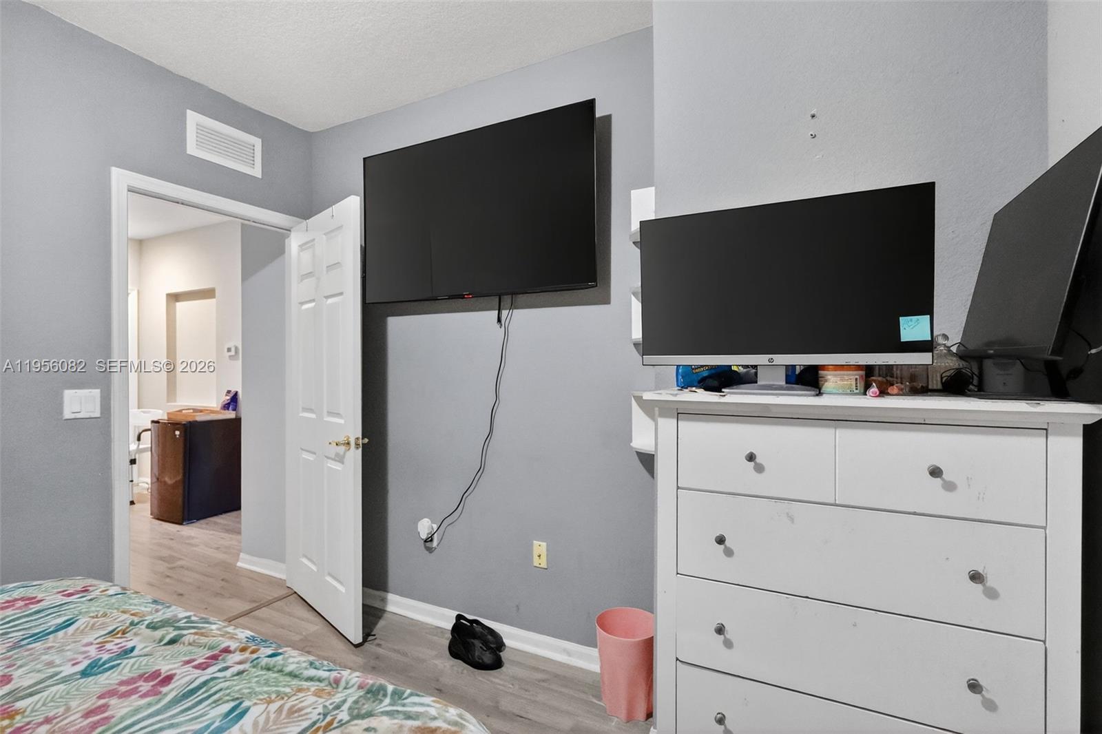 2671 Southwest 85th Terrace, Unit 103 Miramar, FL 33025 - Photo 36 of 49 a living room with flat screen tv on the dresser and gym equipment