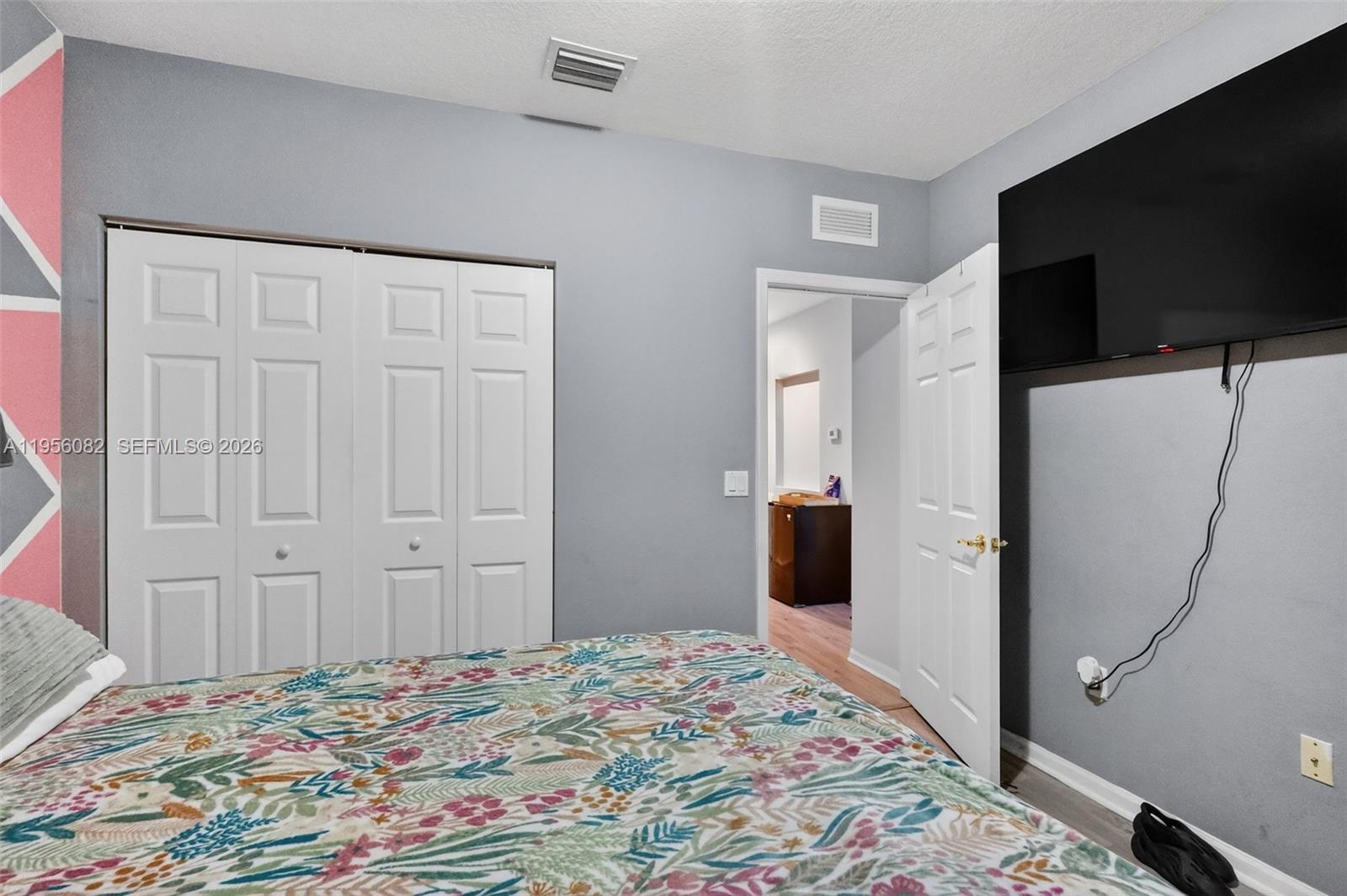 2671 Southwest 85th Terrace, Unit 103 Miramar, FL 33025 - Photo 37 of 49 a bedroom with a bed and a flat screen tv