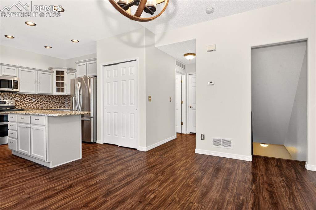7763 Middle Bay Way Fountain, CO 80817 - Photo 11 of 44 a view of kitchen with white wooden cabinets and wooden floor