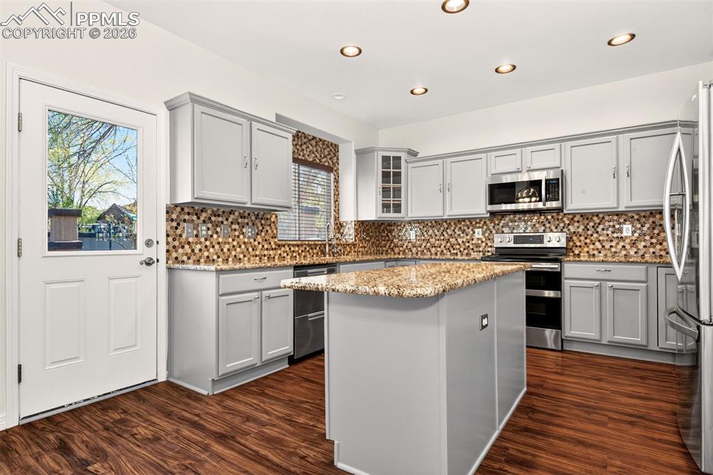7763 Middle Bay Way Fountain, CO 80817 - Photo 12 of 44 a kitchen with granite countertop a sink cabinets stainless steel appliances and a window