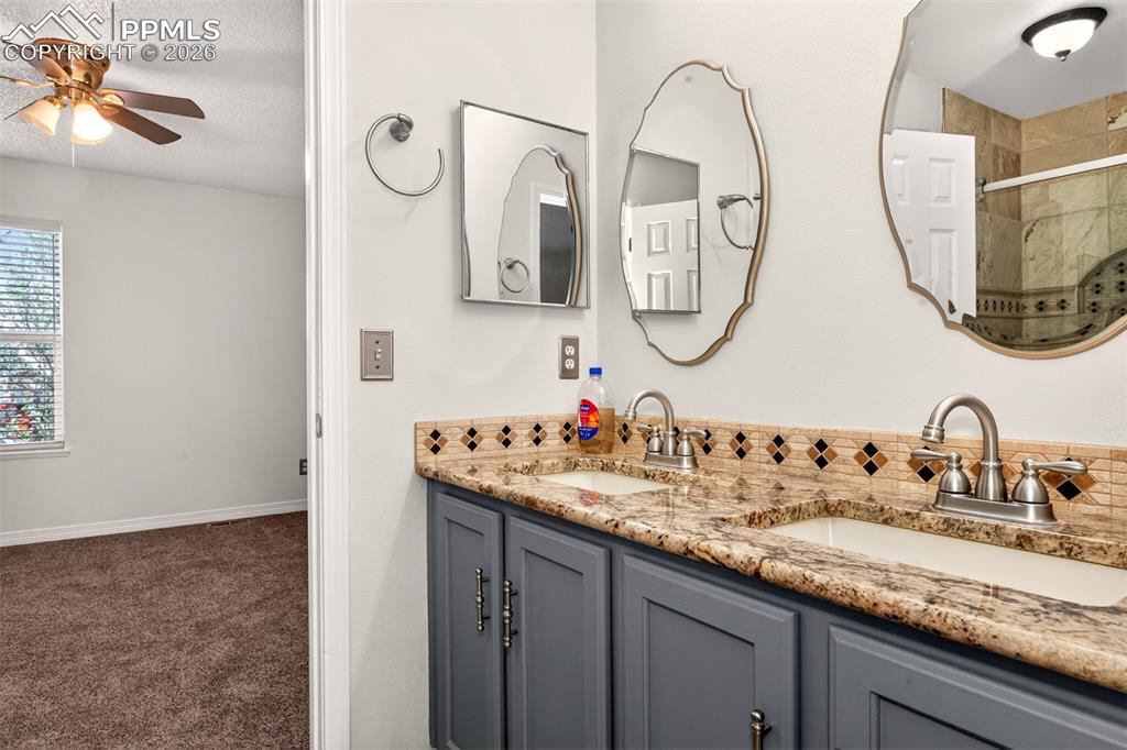 7763 Middle Bay Way Fountain, CO 80817 - Photo 25 of 44 a bathroom with a double vanity sink and a mirror