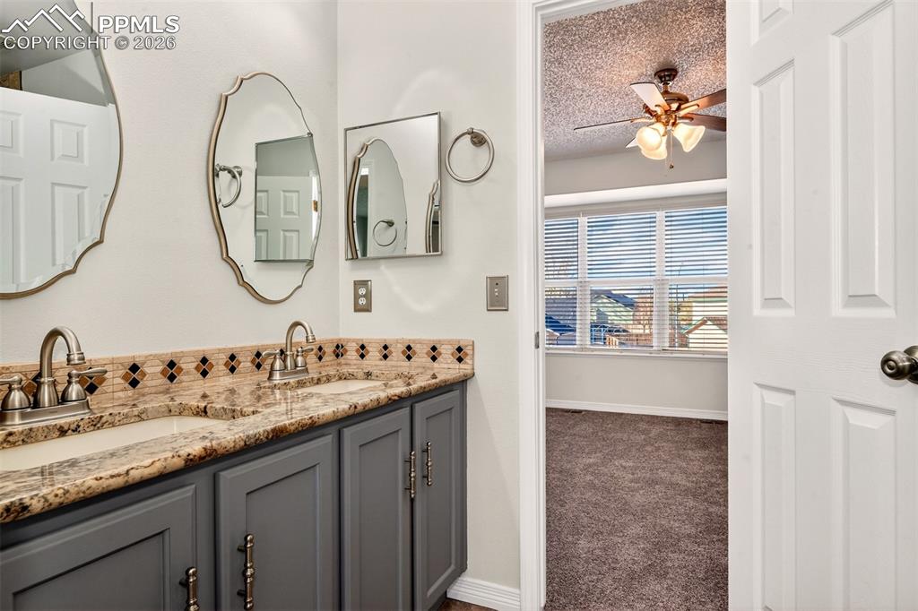 7763 Middle Bay Way Fountain, CO 80817 - Photo 27 of 44 a bathroom with a granite countertop double vanity sink and a mirror