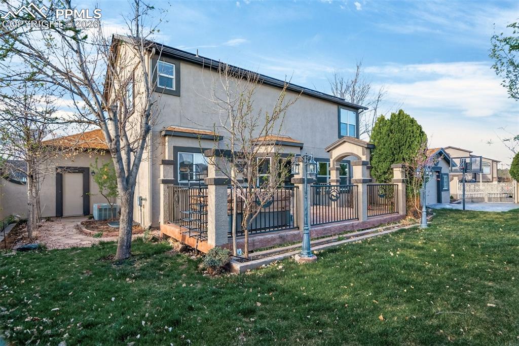 7763 Middle Bay Way Fountain, CO 80817 - Photo 41 of 44 a view of a house with a yard balcony and dinning table and chairs under an umbrella