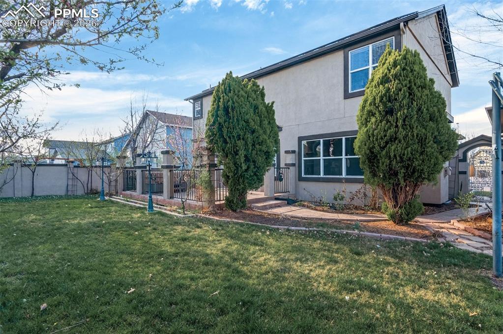 7763 Middle Bay Way Fountain, CO 80817 - Photo 42 of 44 a backyard of a house with wooden fence and large trees