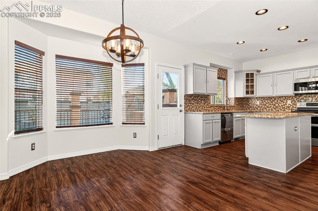 7763 Middle Bay Way Fountain, CO 80817 - Photo 10 of 44 a kitchen with stainless steel appliances granite countertop a stove a sink dishwasher and a large refrigerator with wooden floor