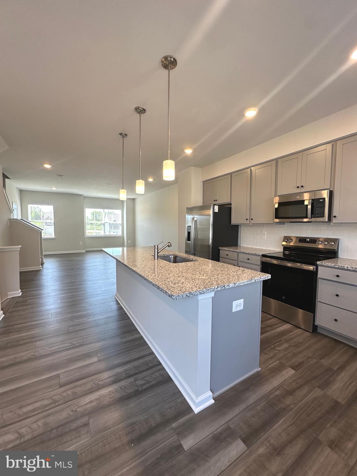 78 Rolling Branch Drive Ranson, WV 25438 - Photo 23 of 49 a large kitchen with stainless steel appliances granite countertop a stove a sink a refrigerator and a wooden floor