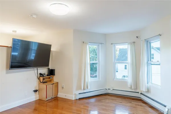 a view of a livingroom with wooden floor and a flat screen tv
