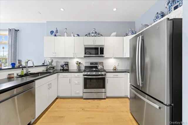 a kitchen with stainless steel appliances granite countertop a refrigerator sink and stove