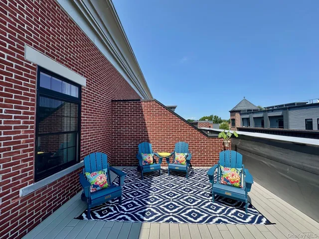 a view of a roof deck with couches and wooden floor