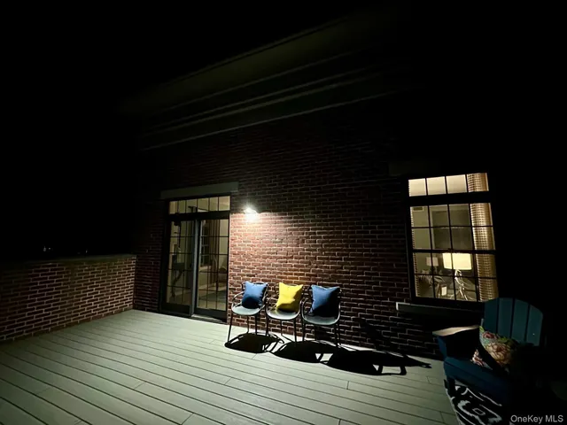 a balcony with wooden floor and outdoor seating