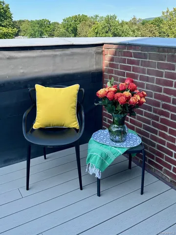 a view of a balcony with two chairs and a potted plant on a wooden floor