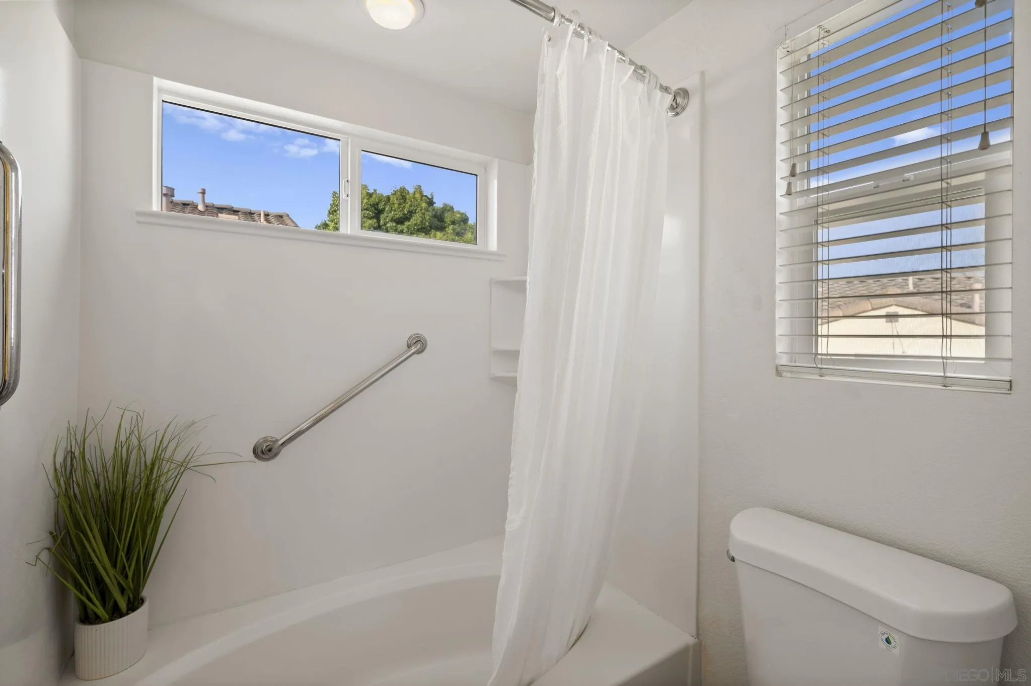 2847 Escala Circle San Diego, CA 92108 - Photo 16 of 35 a bathroom with a toilet and a shower curtain