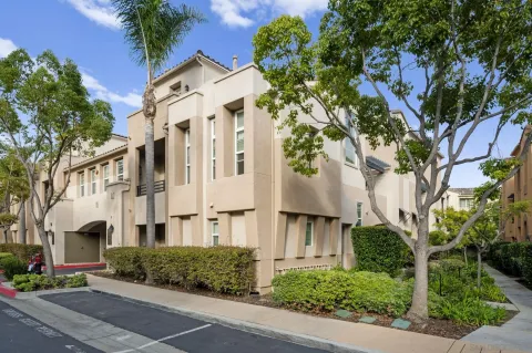 a view of a white building among the street with palm trees