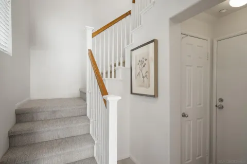 a view of staircase with white walls and a window