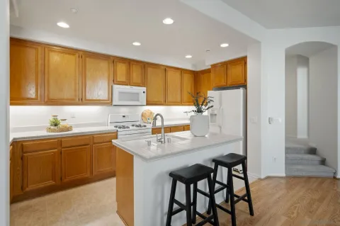 a kitchen with a sink a refrigerator and cabinets