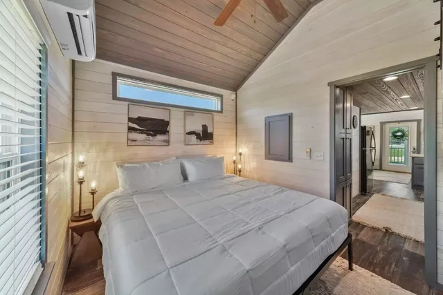 a bedroom with a large bed and a chandelier