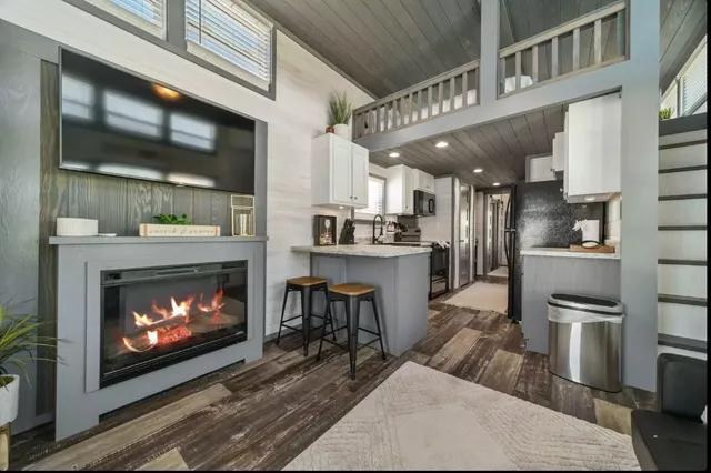 a living room with stainless steel appliances kitchen island a fireplace and a fireplace