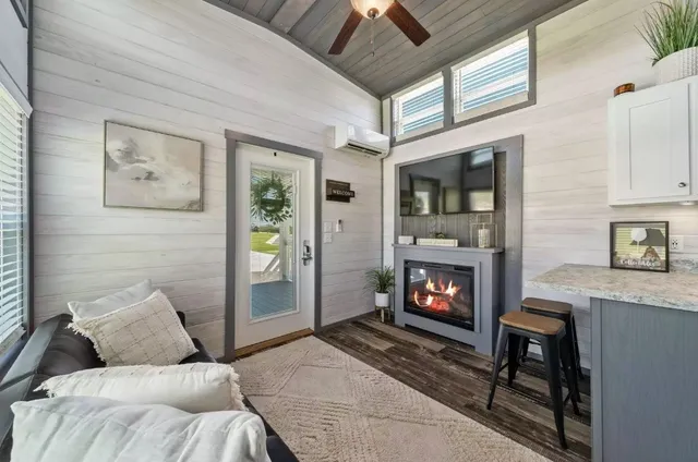 a living room with furniture a fireplace and a flat screen tv
