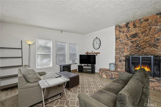 a living room with furniture a fireplace and a flat screen tv