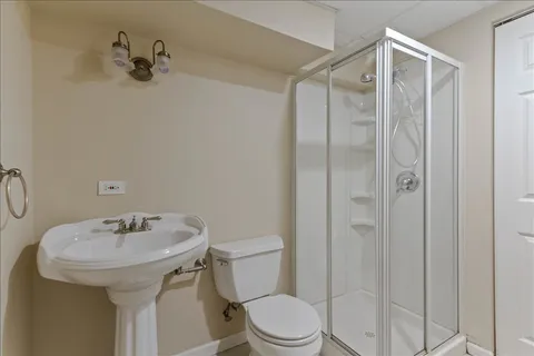 a bathroom with a sink a toilet and shower